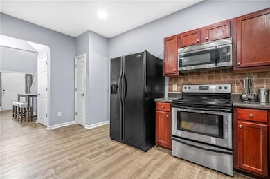 Kitchen featuring stainless steel appliances, dark