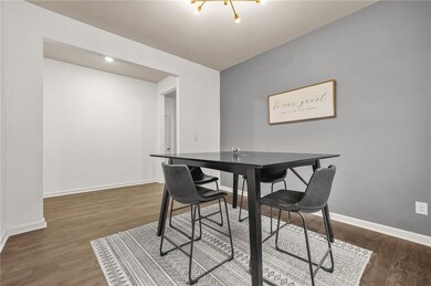 Dining area featuring dark wood-style flooring and baseboards