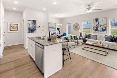 Kitchen featuring sink, white cabinetry, dishwashe