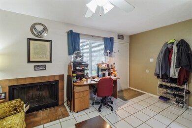 Office space with a tiled fireplace, a ceiling fan