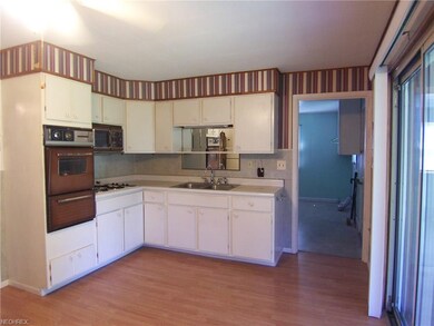 The kitchen has white cabinets and a vintage wall 