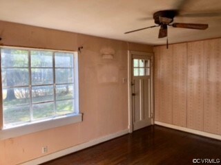 Foyer entrance with ceiling fan and dark wood-type