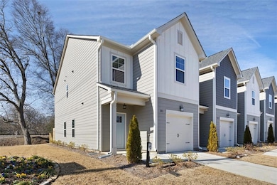 View of front facade with board and batten siding, a garage, and driveway