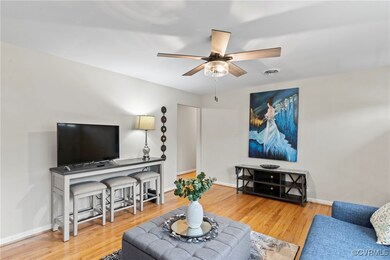 Living room featuring a ceiling fan, wood finished