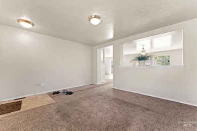 Spare room featuring carpet floors and baseboards