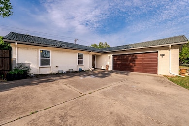 Ranch-style home with a tiled roof, concrete drive