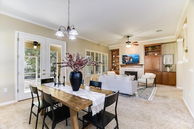 Dining room with light carpet, ceiling fan, frenc