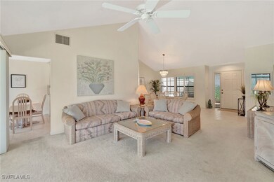 Living area featuring light carpet, high vaulted c