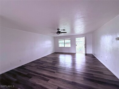 Empty room with dark wood-style floors, ceiling fa