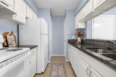 The kitchen has black and grey granite countertops