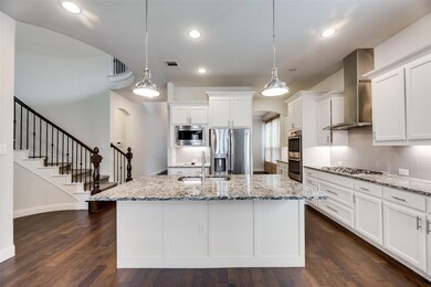 Open concept Kitchen featuring dark hardwood throughout granite countertops with large island undercount light and stainless steel appliances. Refrigerator included