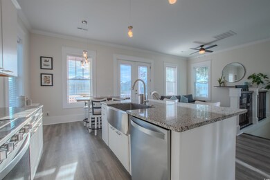 Kitchen with white cabinets, pendant lighting, sta