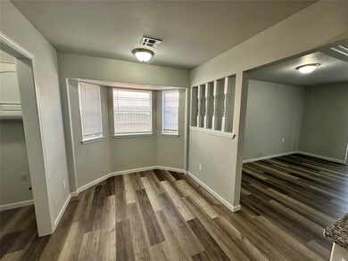 Empty room featuring dark wood-type flooring and baseboards