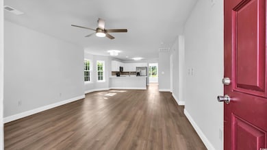 Unfurnished living room featuring a ceiling fan and wood finished floors