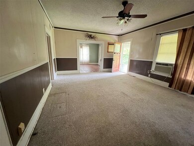 Unfurnished living room featuring crown molding, a