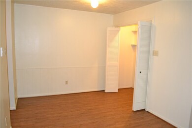Unfurnished bedroom with a textured ceiling, wood