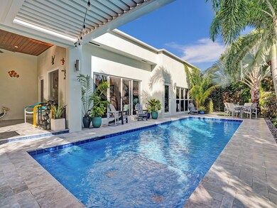 Private tropical backyard with pool, pergola, patio, outdoor shower, and landscape lighting.