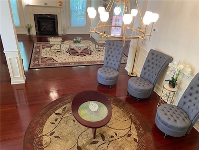 Living area featuring wood finished floors, a chandelier, baseboards, and a premium fireplace