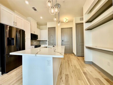 Kitchen with a kitchen island with sink, stainless