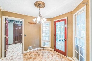 Foyer entrance featuring a chandelier, baseboards, stone finish flooring, and a textured ceiling