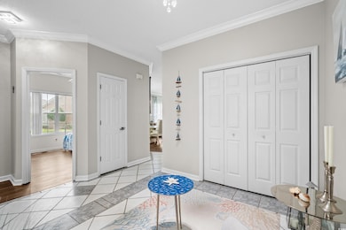 Unfurnished bedroom featuring light tile patterned flooring, multiple windows, ornamental molding, and baseboards