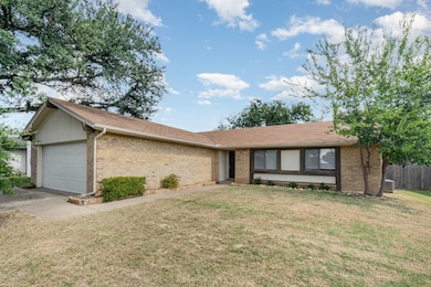 Single story home featuring brick siding, a garage, and roof with shingles