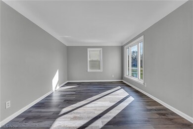 Empty room with dark hardwood / wood-style floors