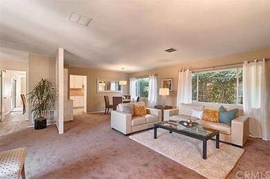 A view of both formal living room and dining room which shows the open concept and how big the space is.