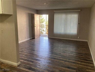 Empty room featuring a textured ceiling and dark h