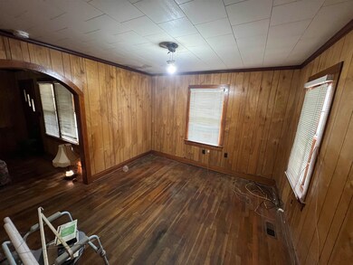 Spare room with wooden walls and dark wood-type fl