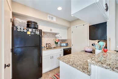 Kitchen featuring visible vents, a sink, black app