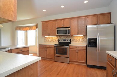 The kitchen includes hardwood floors, stainless ap