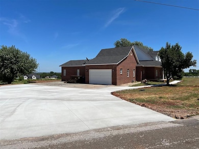 View of side of property with brick siding, concrete driveway, and a garage