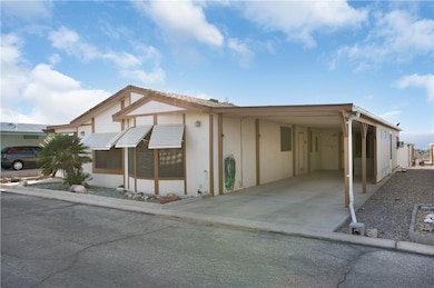 View of front of house with an attached carport and driveway.