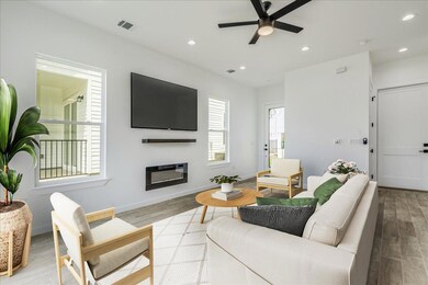 Open living area with kitchen, dining, and access to outdoor patio.