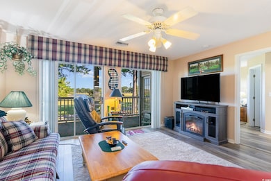 Living room featuring ceiling fan and light hardwo