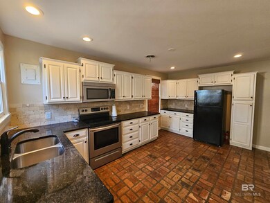 Kitchen featuring white cabinetry, appliances
