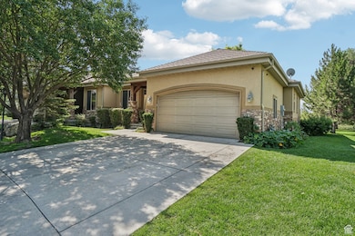 View of front of property featuring stone siding, stucco siding, a front yard, an attached garage, and concrete driveway