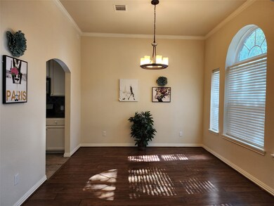 Dining with elegant light fixture and arch window,
