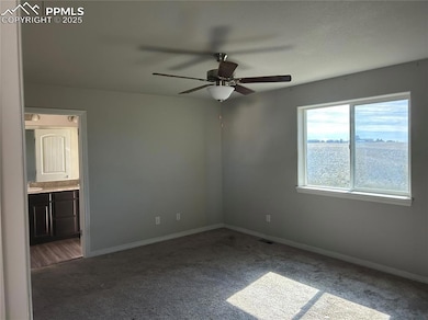 Unfurnished bedroom with carpet, ceiling fan, and ensuite bath