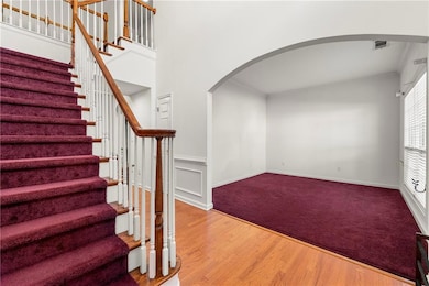Staircase with arched walkways, wood finished floo