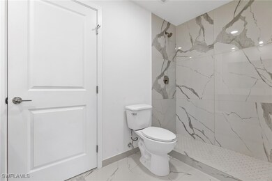 Full bath with a marble finish shower, marble fini