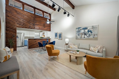 Living room with high vaulted ceiling, light wood