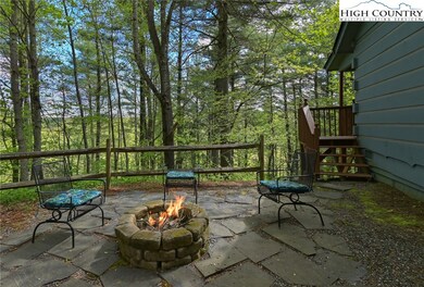 Back of the house with stone patio, firepit, trees