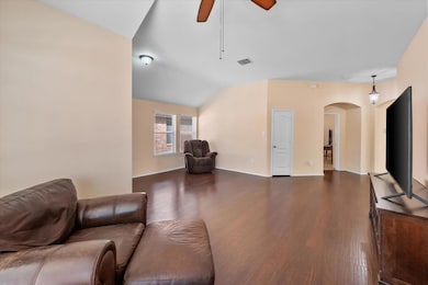 Living room with wood finished floors, arched walk