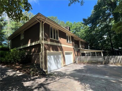 View of back of house with an attached garage and driveway