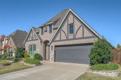 View of front facade with brick siding, roof with shingles, a garage, and concrete driveway