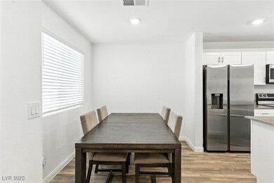 Dining room with light wood-style floors and recessed lighting