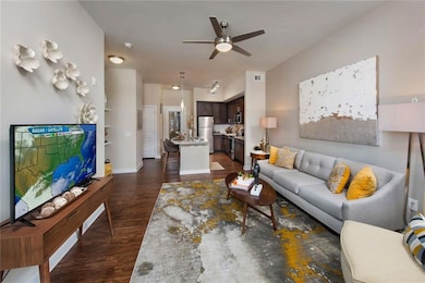 Living room featuring dark hardwood / wood-style floors and ceiling fan