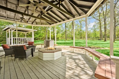 Back yard covered porch with wood decking, fans and plenty of space to relax. View to the left of the covered grilling porch.